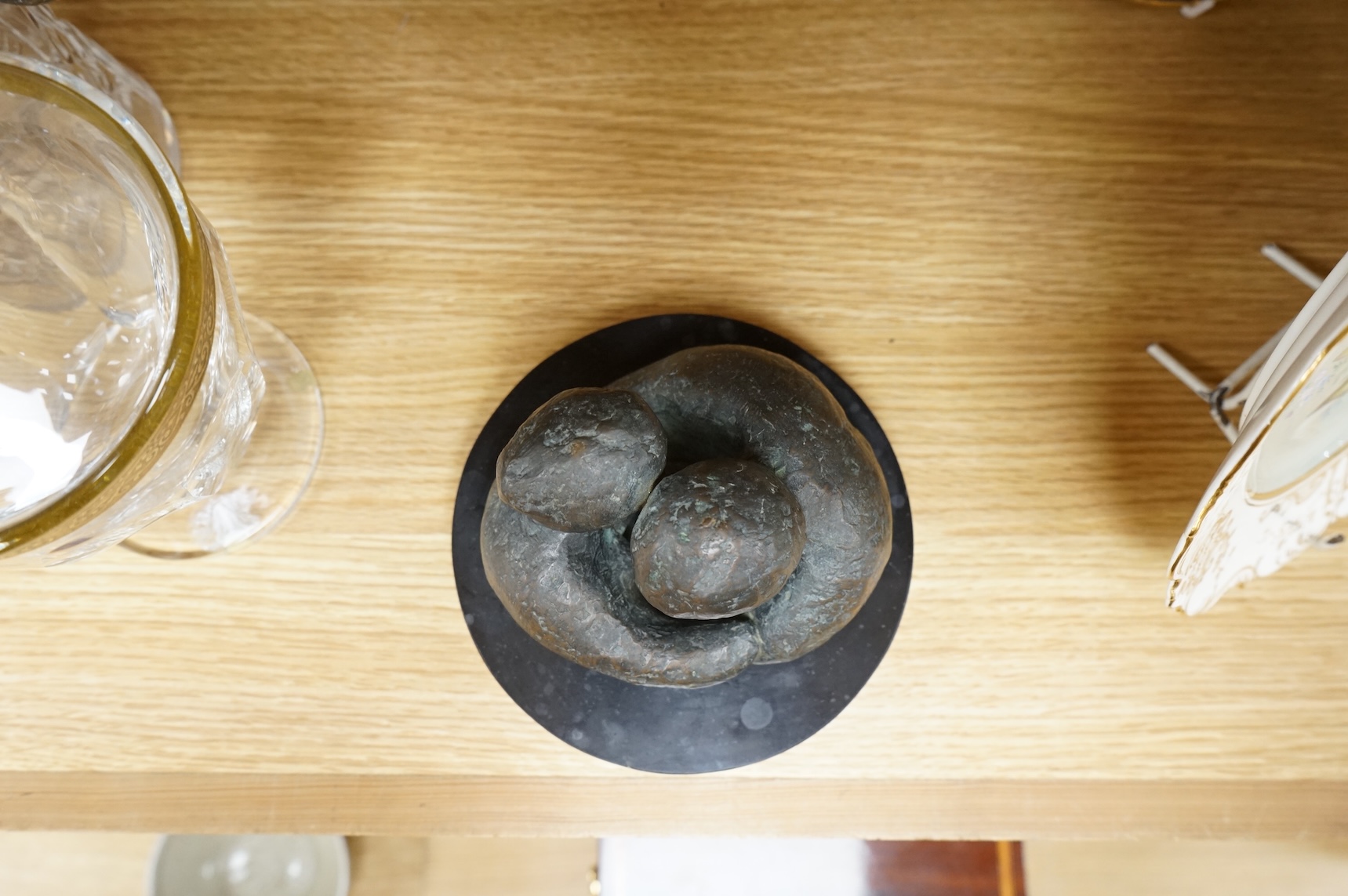 A contemporary bronze revolving sculpture of an embracing couple, unsigned, 16cm in diameter